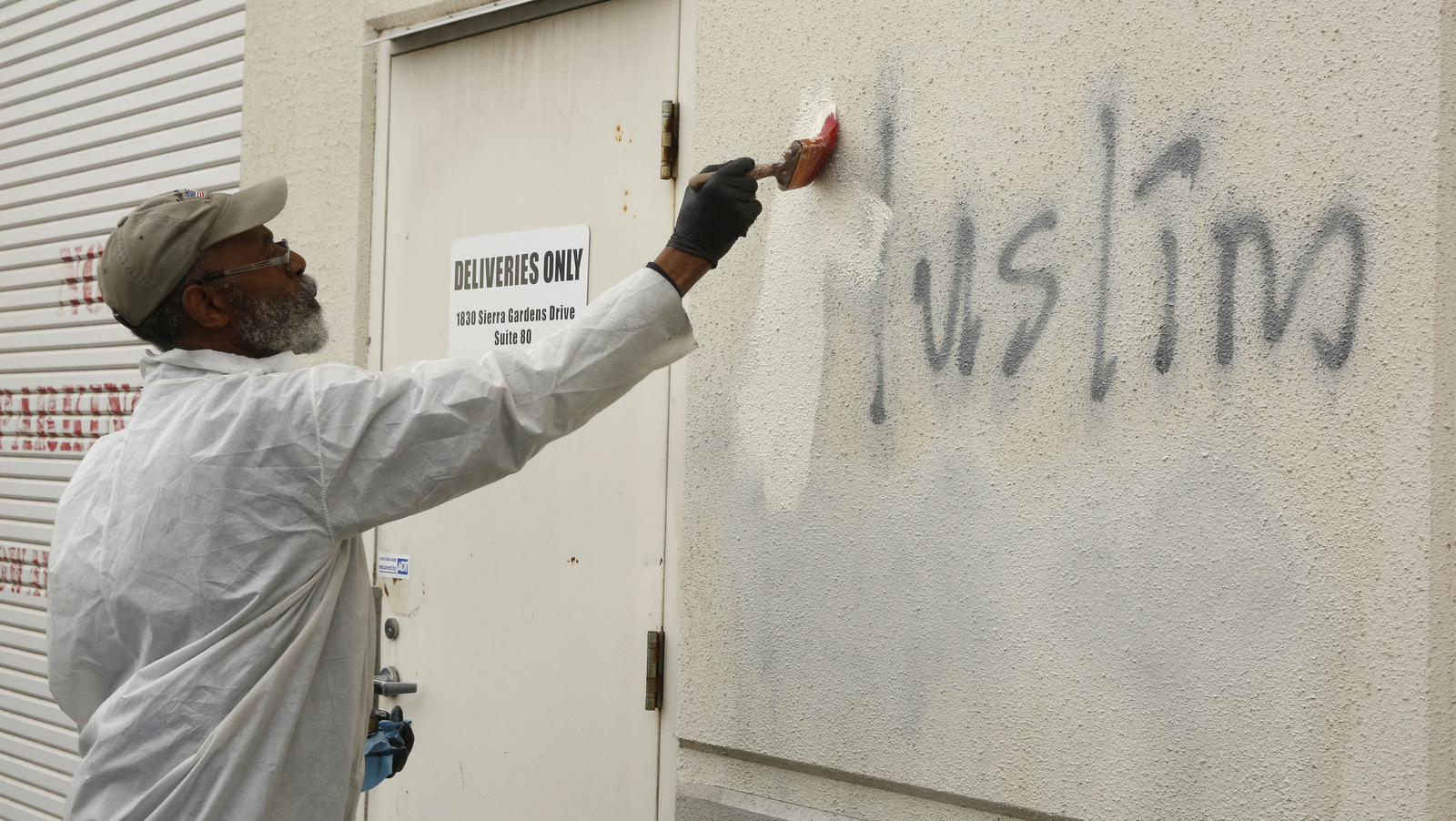 Willie Lawson paints over racist graffiti painted on the side of a mosque in Roseville, Calif. (AP/Rich Pedroncelli)