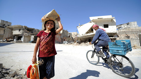 A girl is seen at a damaged site in Aleppo's Sheikh Maqsoud neighbourhood, Syria. © Omar Sanadiki