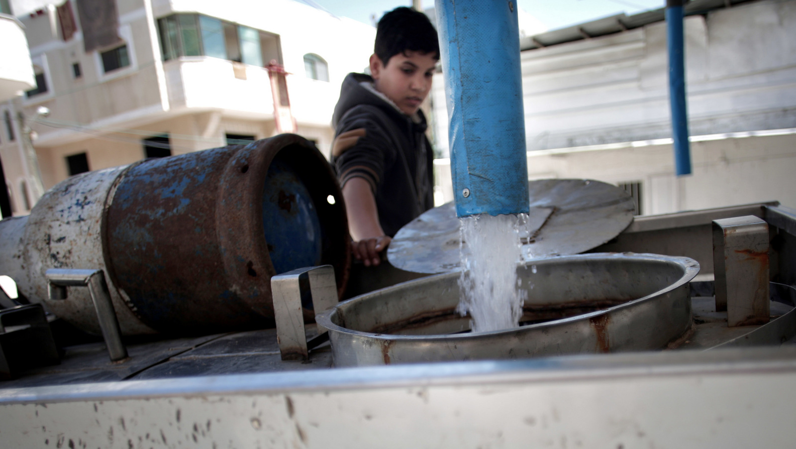 A Palestinian man fills tankers with drinking water for sale at a drinking water station in Gaza City. Poor sewage treatment is a feature of life in Gaza, a result of infrastructure damaged during wars with Israel and a chronic shortage of electricity to run wastewater plants. (AP/Khalil Hamra)