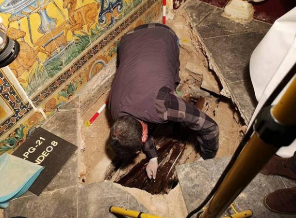 Archaeologists excavating the Alcázar burial of a young child from beneath the floor of a chapel within the Real Alcázar in Seville