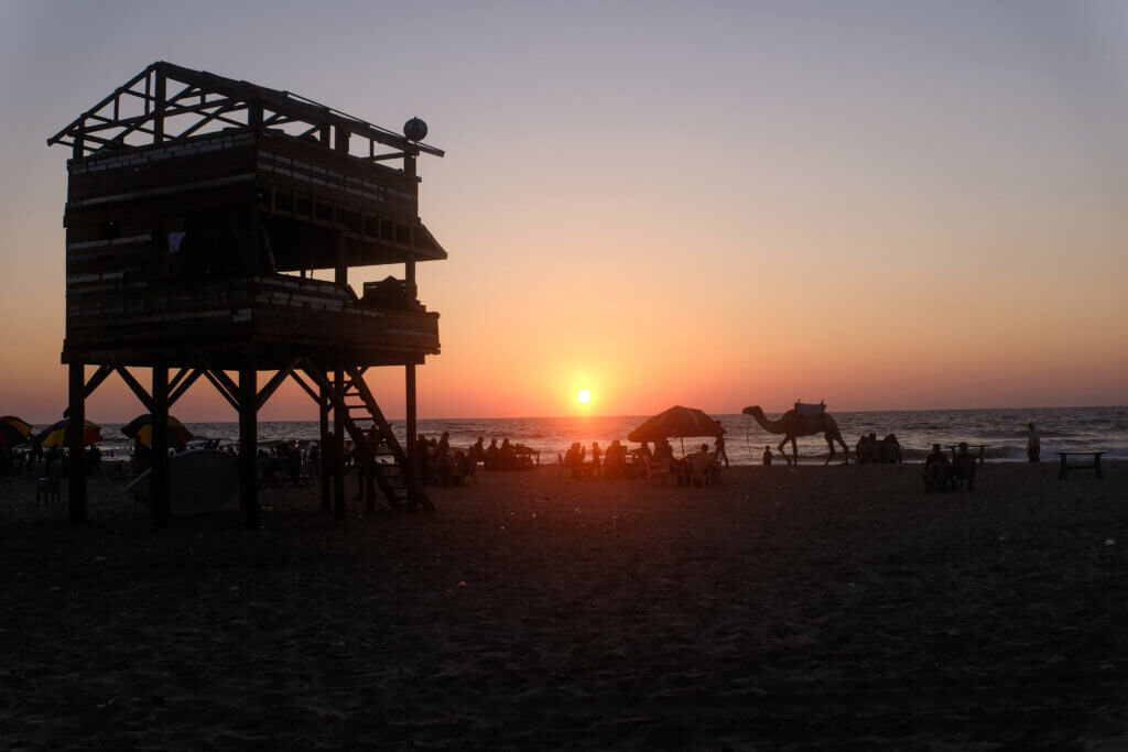 Families gather to swim under the watchful eye of a lifeguard tower in a beach near Al-Rasheed Street in Gaza City, on August 11, 2021. (Photo: Mahmoud Nasser)