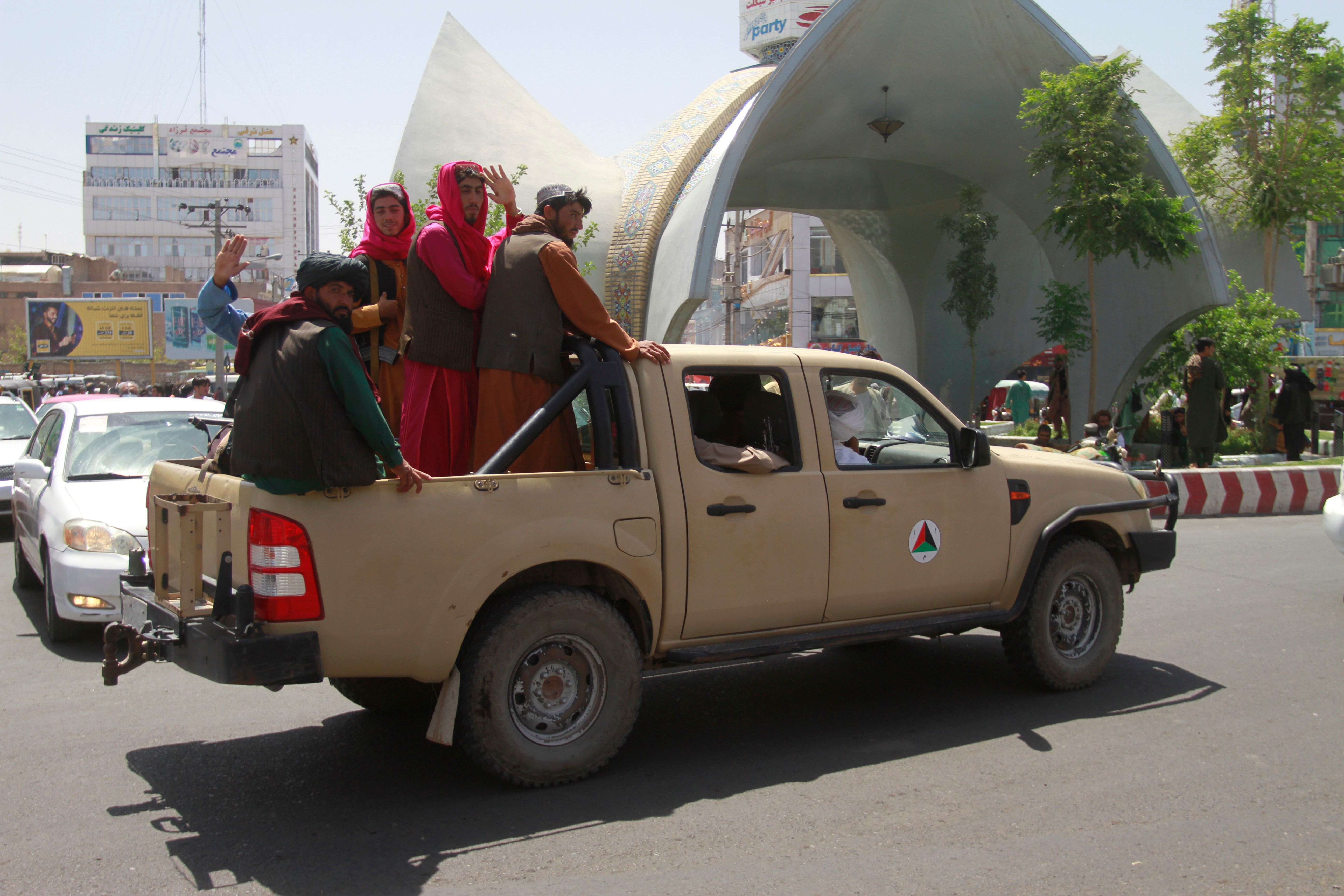 Taliban fighters pose on the back of a vehicle in the city of Herat, west of Kabul, Afghanistan, Saturday, Aug. 14, 2021, aft