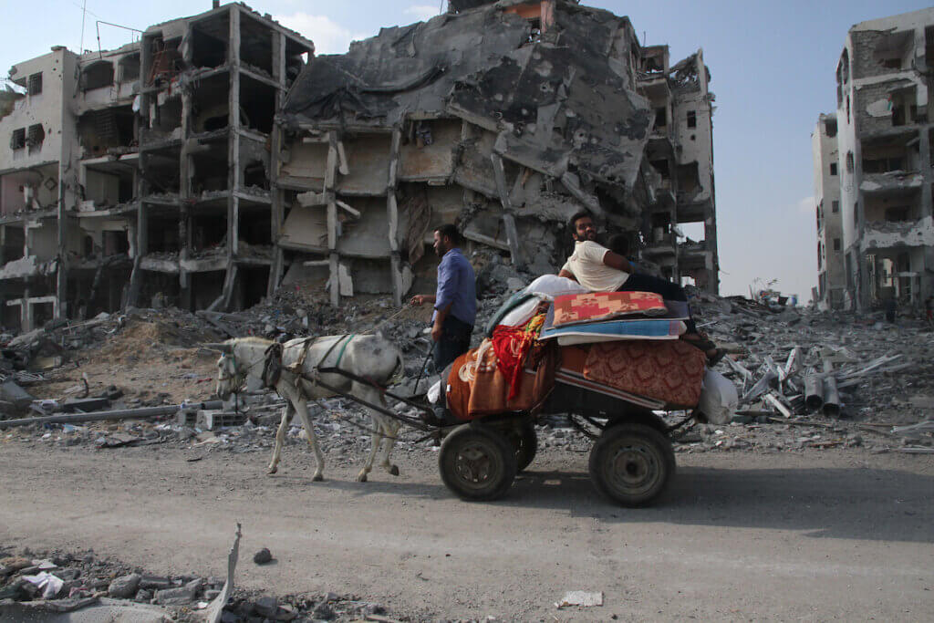 Members of a Palestinian family ride in a donkey cart as they return to their house in Beit Lahiya, which witnesses said was heavily hit by Israeli shelling and air strikes during the Israeli offensive, in the northern Gaza Strip August 5, 2014. (Photo: Naaman Omar/APA Images)