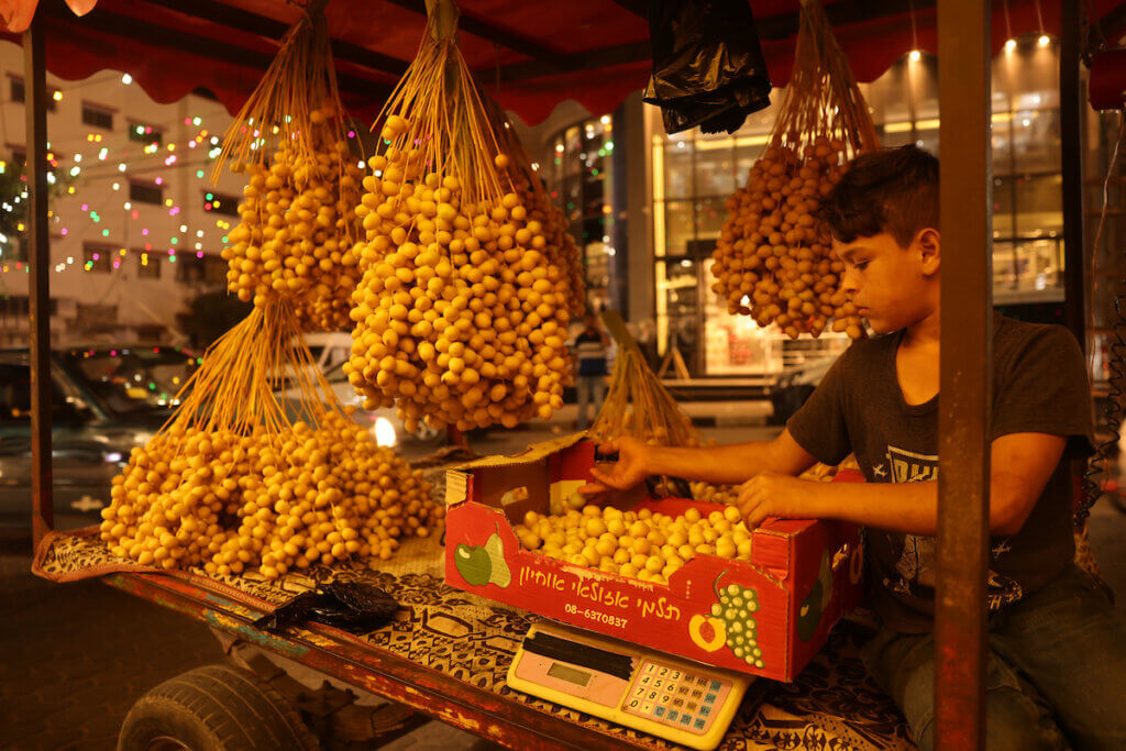 A Palestinian boy sells dates from a donkey cart at street in Gaza city on August 31, 2021. (Photo: Osama Baba/APA Images)