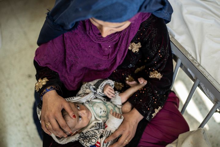 Saliha holds her four-month old baby Najeeb as he undergoes treatment at the malnutrition ward of the Indira Gandhi Children's Hospital in Kabul, Afghanistan, Wednesday, Dec. 8, 2021. (AP Photo/Petros Giannakouris)