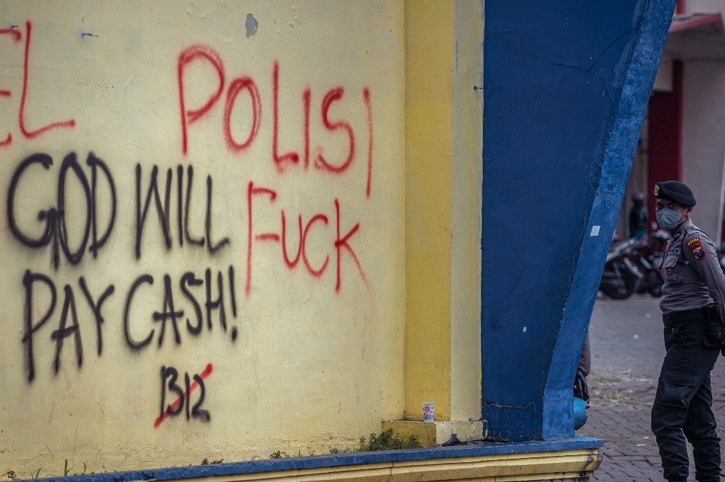 A police officer stands guard outside Kanjuruhan stadium during a visit by Indonesia's President Joko Widodo days after the deadly stampede. In the wake of the tragedy, public anger has surged at long-standing police violence during football events. 