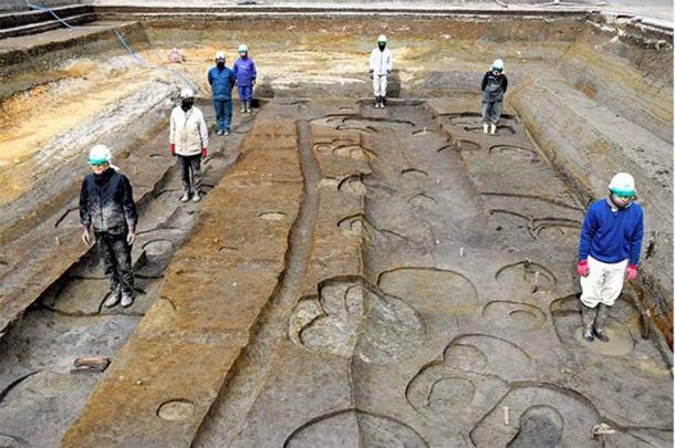 Researchers stand where massive timber pillars once stood to give a perspective on the size of the site of the home of Prince Toneri in Nara. Source: Nara City Board of Education/Asahi