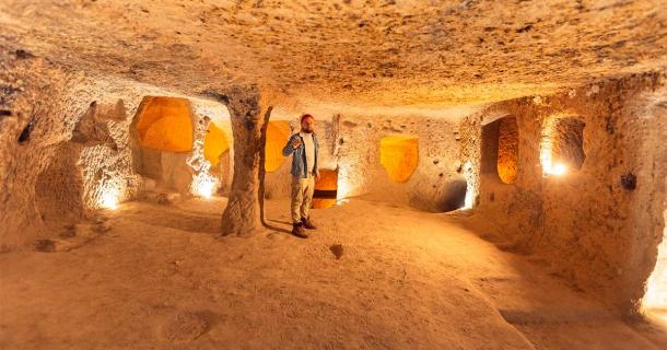 Man standing in underground city of Derinkuyu, Turkey. Source: Parilov / Adobe Stock.