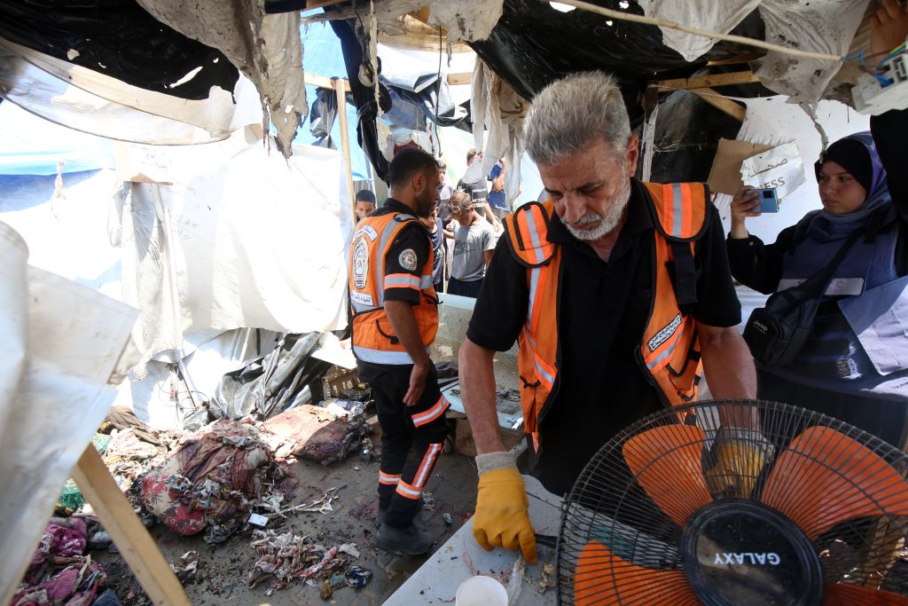 Palestinian first responders assess the damage after a tent marked as 'press' was targeted in an Israeli attack in the central Gaza Strip.