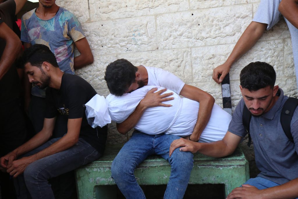 Relatives of Palestinians killed in Israeli attacks mourn as they receive loved ones' bodies from the morgue of Al-Aqsa Hospital for burial in Deir El-Balah, Gaza on July 18, 2024. (Photo: Ali Hamad/APA Images)