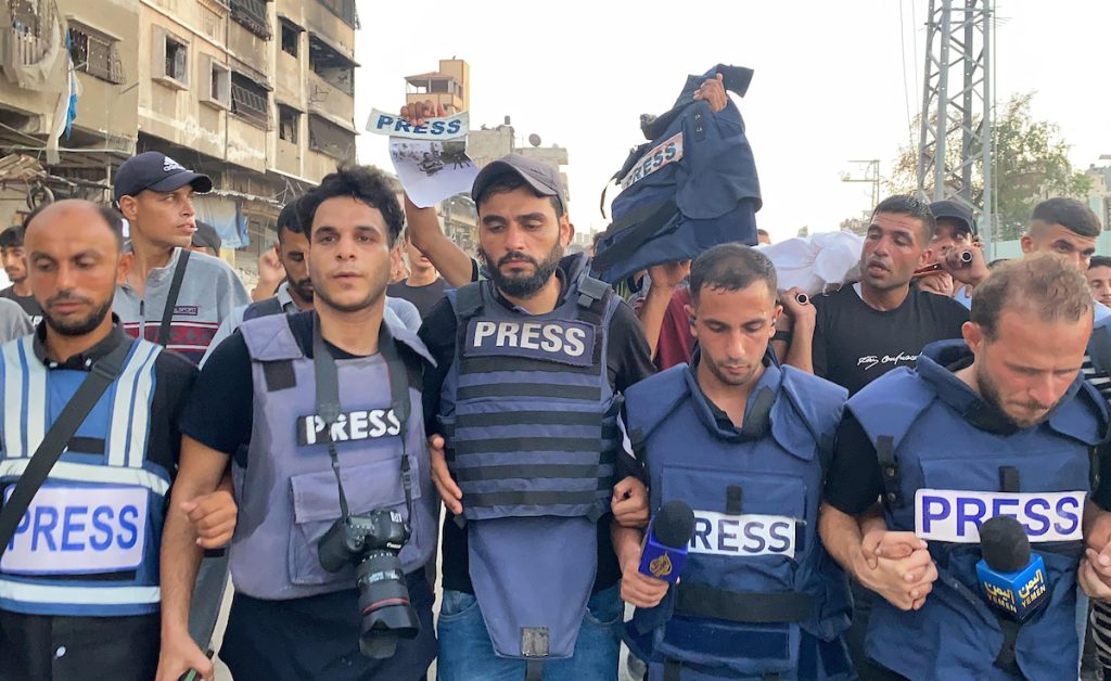 Mourners and colleagues surround the bodies of Al-Jazeera Arabic journalist Ismail al-Ghoul and cameraman Rami al-Refee, killed in an Israeli strike during their coverage of Gaza's Al-Shati refugee camp, on July 31, 2024. Al Jazeera condemned the killing of two of its journalists, calling the deaths a "cold-blooded assassination" in a statement. (Photo: Hadi Daoud/APA Images)