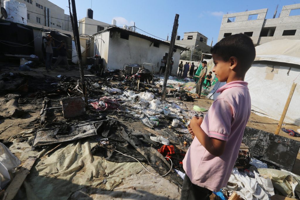 A Palestinian boy looks at the rubble of burned tents that were targeted by an Israeli bomb.