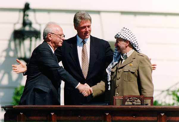 Israeli Prime Minister Yitzhak Rabin (left), U.S. president Bill Clinton (center), and PLO chairman Yasser Arafat (right), during the signing of the Oslo Accords, September 13, 1993.